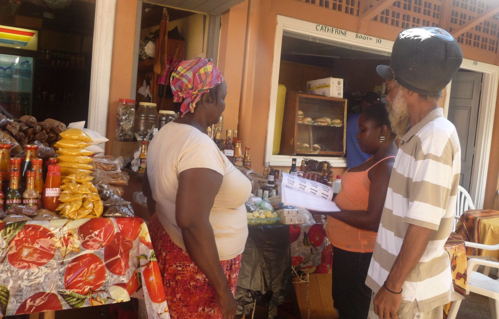 Shoppers browsing spices, sauces and local goods at a stall in Castries Market, St. Lucia